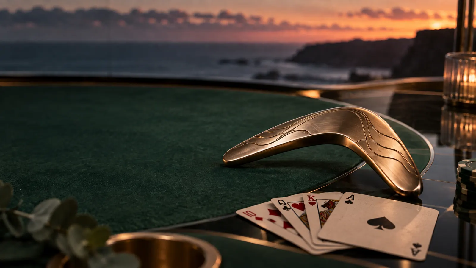 A metallic boomerang token and playing cards on a refined casino-style tabletop at dusk